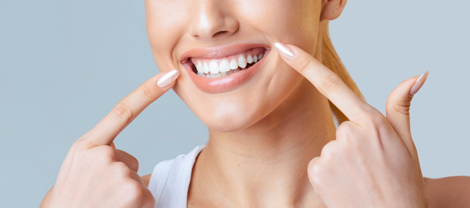Woman pointing to her bright white smile