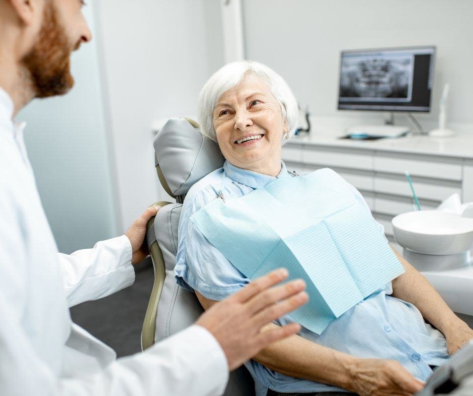 Smiling senior woman talking with her dentist in the treatment chair