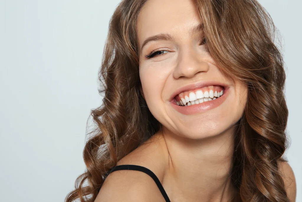 Close-up of a young woman with curly hair smiling