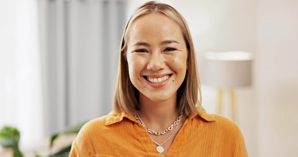 Smiling young woman in a mustard top