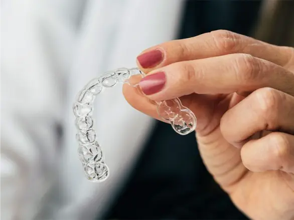 Hand holding a clear aligner