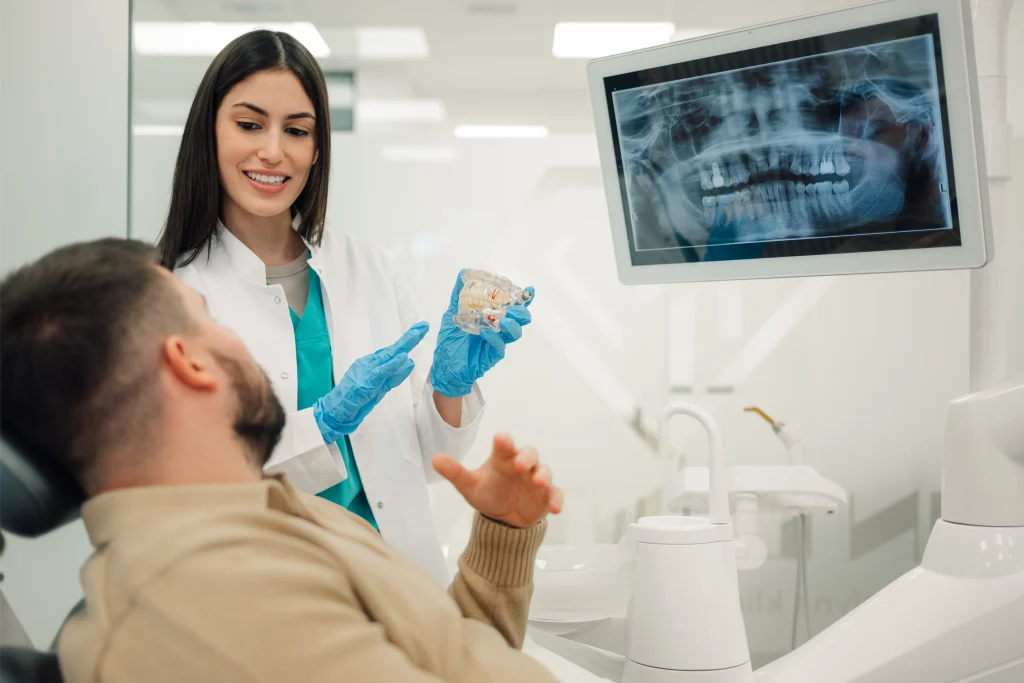Dentist explaining a panoramic X-ray to a patient in the treatment chair