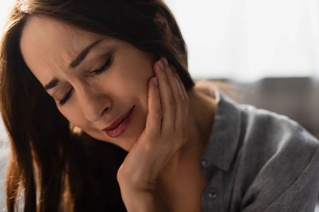 Woman holding her jaw in pain from toothache