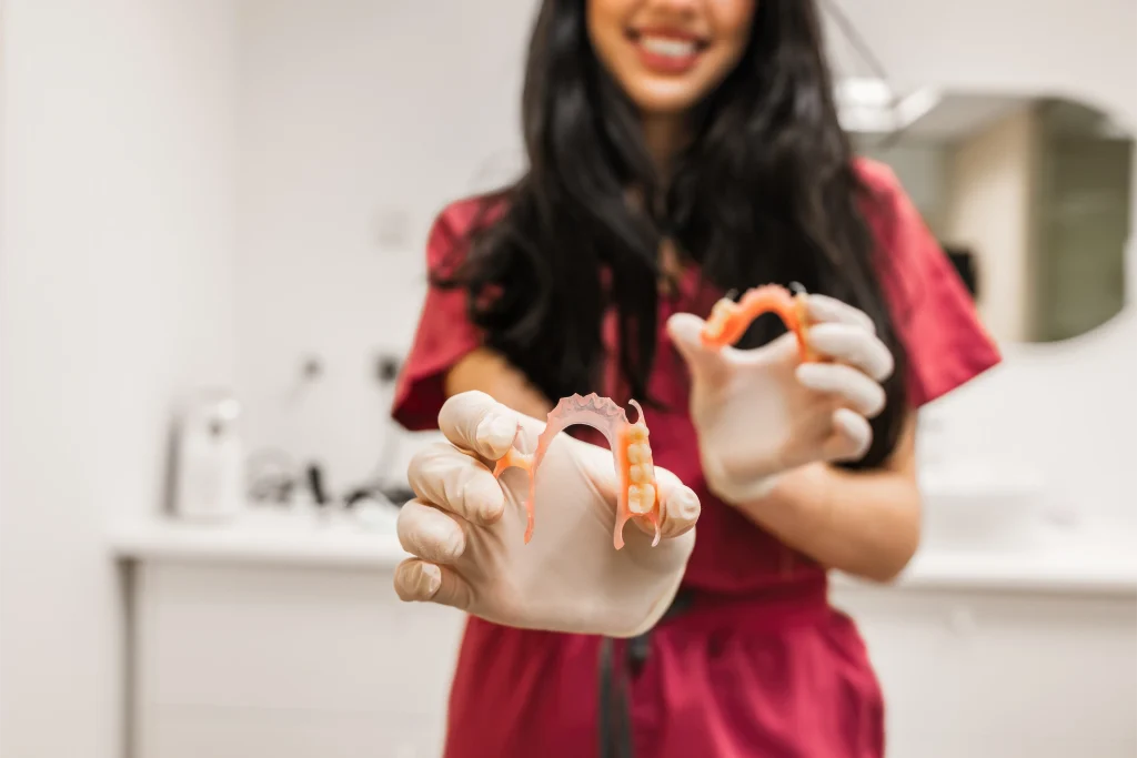 Dental professional holding a partial denture