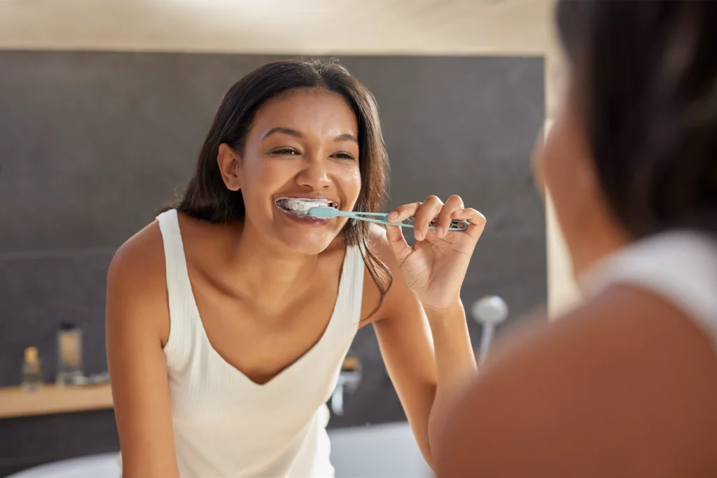 Woman brushing her teeth in a bright bathroom